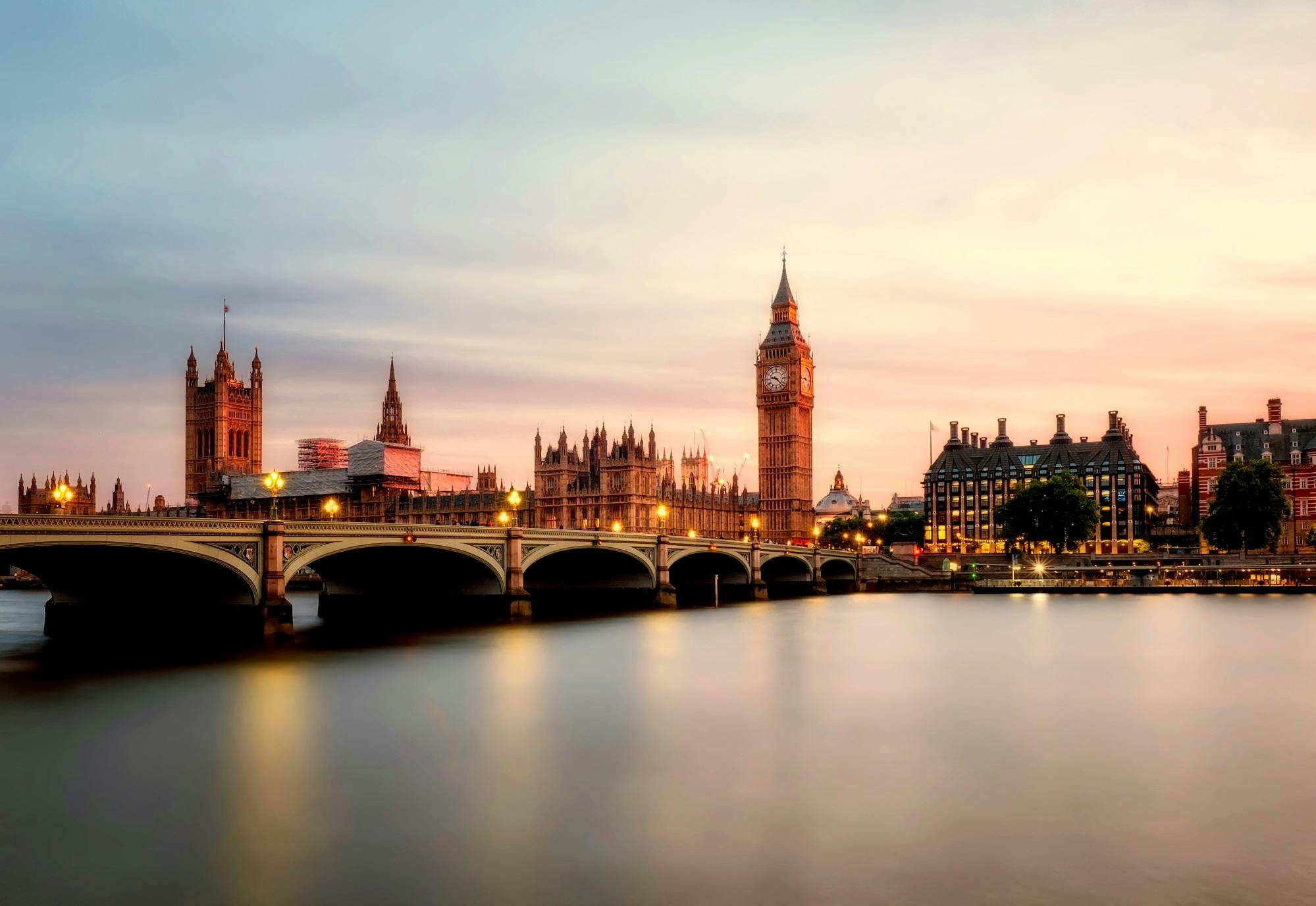 Flight deals to see scenic view of Big Ben and Westminster Bridge over the Thames River at sunset in London, UK.